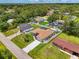 An aerial view of the home highlighting the backyard, screened pool, lush lawn, and surrounding homes in the neighborhood at 4038 Corydon Ave, North Port, FL 34286