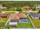 Aerial view of a home with a screened pool, shed, fenced yard, and lush green lawn at 4038 Corydon Ave, North Port, FL 34286