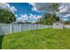 Spacious backyard featuring a white fence, lush green grass, and a convenient storage shed at 4038 Corydon Ave, North Port, FL 34286