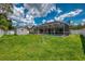 Expansive backyard view showcasing a screened pool enclosure, storage shed, and well-maintained lawn at 4038 Corydon Ave, North Port, FL 34286