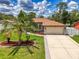 Charming home exterior with a well-manicured lawn, landscaping, and a two-car garage at 4038 Corydon Ave, North Port, FL 34286