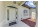 Welcoming front entrance featuring a classic white door with sidelights, complemented by meticulously landscaped surroundings at 4038 Corydon Ave, North Port, FL 34286