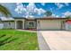 Charming single-story home with a well-manicured lawn, complemented by an attached two-car garage and neutral color palette at 4038 Corydon Ave, North Port, FL 34286