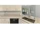 Modern kitchen with stainless steel dishwasher and double sinks overlooking the outdoor pool and patio area at 4038 Corydon Ave, North Port, FL 34286