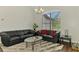 Comfortable living room with black leather sofas, glass coffee table, and views to the outdoor backyard at 4038 Corydon Ave, North Port, FL 34286