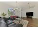 Bright living room features expansive window, chandelier, and comfortable seating with laminate flooring at 4038 Corydon Ave, North Port, FL 34286