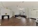 Bright living room featuring dark wood floors, large window, and black leather furniture set for relaxing and entertaining at 4038 Corydon Ave, North Port, FL 34286