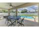 Covered patio with table and chairs, ceiling fan, and view of the sparkling pool at 4038 Corydon Ave, North Port, FL 34286