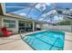 Inviting pool with clear blue water, a sun-drenched patio, screened enclosure, and outdoor seating at 4038 Corydon Ave, North Port, FL 34286