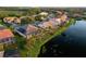 Scenic aerial view showcasing a home with solar panels and a screened-in lanai on a picturesque lake at 4334 Corso Venetia Blvd, Venice, FL 34293