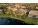 Aerial view of the backyard with a screened-in lanai, lush landscaping and a peaceful lake at 4334 Corso Venetia Blvd, Venice, FL 34293