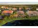 Aerial shot showing a backyard with screened-in lanai, manicured lawn, and a tranquil lake setting at 4334 Corso Venetia Blvd, Venice, FL 34293