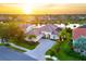 Beautiful aerial shot of a sun-drenched home with tile roof, lush landscaping, and a serene lake view in a lovely neighborhood at 4334 Corso Venetia Blvd, Venice, FL 34293