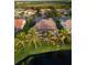 Scenic aerial view of a home with a screened-in lanai, mature landscaping and a view of the lake at 4334 Corso Venetia Blvd, Venice, FL 34293