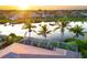 Aerial view of a backyard with a screened-in pool overlooking a serene lake at sunset at 4334 Corso Venetia Blvd, Venice, FL 34293