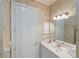 Well-lit bathroom featuring a vanity with a large mirror and floral wallpaper at 4334 Corso Venetia Blvd, Venice, FL 34293