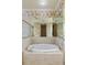Inviting bathroom with a relaxing soaking tub and a large mirror with a view into the hallway at 4334 Corso Venetia Blvd, Venice, FL 34293