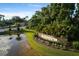 Community entrance sign with lush landscaping, a pond, and stately trees at 4334 Corso Venetia Blvd, Venice, FL 34293