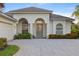 Attractive home featuring arched entry with paver driveway and lush landscaping at 4334 Corso Venetia Blvd, Venice, FL 34293