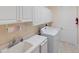 Functional laundry room with white cabinets, sink, and modern washing machine at 4334 Corso Venetia Blvd, Venice, FL 34293
