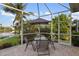 Outdoor patio features a dining table and chairs, nestled within a screened enclosure, providing a lovely outdoor dining experience at 4334 Corso Venetia Blvd, Venice, FL 34293
