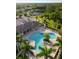 Aerial view of a community pool area with palm trees, lounge chairs, and a clubhouse at 4334 Corso Venetia Blvd, Venice, FL 34293