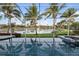 Screened pool with lake view features tropical landscaping, a spa, and a serene setting, perfect for relaxation and entertainment at 4334 Corso Venetia Blvd, Venice, FL 34293