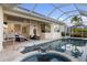 Outdoor pool and spa area transitions seamlessly into the home, with comfortable seating and a spacious patio for relaxation at 4334 Corso Venetia Blvd, Venice, FL 34293