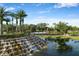Scenic water feature with a cascading waterfall and surrounding lush landscaping at 4334 Corso Venetia Blvd, Venice, FL 34293