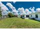 Spacious backyard featuring a shed, green lawn, and a view of the home's exterior at 720 Dalton Blvd, Port Charlotte, FL 33952