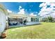 Spacious backyard featuring a covered patio with outdoor seating, a grill, and a well-maintained lawn at 720 Dalton Blvd, Port Charlotte, FL 33952