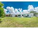 Wide view of the backyard with a well-maintained lawn, shed, and back of the house at 720 Dalton Blvd, Port Charlotte, FL 33952