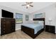 Comfortable bedroom featuring wood-look floors, ceiling fan, a flat screen TV, and decor at 720 Dalton Blvd, Port Charlotte, FL 33952