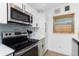 Close-up of kitchen with stainless steel oven, white cabinets, and complementary backsplash at 720 Dalton Blvd, Port Charlotte, FL 33952