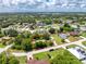 Beautiful aerial view of a property showcasing its spacious lot with mature trees and surrounding neighborhood at 976 Great Falls Nw Ter, Port Charlotte, FL 33948