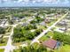 Residential neighborhood aerial view showcasing homes surrounded by trees and green spaces, with a clear blue sky above at 976 Great Falls Nw Ter, Port Charlotte, FL 33948