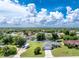 Aerial view of a residential neighborhood with tree-lined streets and well-maintained homes and large grassy lots at 976 Great Falls Nw Ter, Port Charlotte, FL 33948