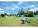 Expansive backyard features mature trees, fire pit, and RV parking, perfect for outdoor activities and relaxation at 976 Great Falls Nw Ter, Port Charlotte, FL 33948