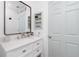 Stylish bathroom featuring a vanity with a marble countertop, and a coastal-themed mirror above the sink at 976 Great Falls Nw Ter, Port Charlotte, FL 33948