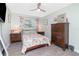 Cozy bedroom with natural light, ceiling fan, wood-look flooring, and floral accents creating a warm atmosphere at 976 Great Falls Nw Ter, Port Charlotte, FL 33948