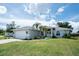 Inviting home featuring a two-car garage, RV parking, and manicured landscaping at 976 Great Falls Nw Ter, Port Charlotte, FL 33948
