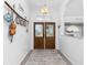 Bright foyer with decorative glass double doors, arched transom window, and coastal-themed decor at 976 Great Falls Nw Ter, Port Charlotte, FL 33948