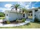 Charming home entrance with a yellow double door and palm trees in the front yard at 976 Great Falls Nw Ter, Port Charlotte, FL 33948