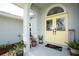 Inviting front porch with decorative yellow doors, glass inserts, and welcome mat at 976 Great Falls Nw Ter, Port Charlotte, FL 33948