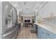 Modern kitchen with stainless steel appliances, a desk area, and bright white and blue cabinetry at 976 Great Falls Nw Ter, Port Charlotte, FL 33948