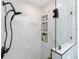 Close up of renovated glass enclosed shower with sleek fixtures and tiled walls with built in nooks for toiletries at 976 Great Falls Nw Ter, Port Charlotte, FL 33948