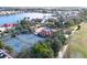 Aerial view of the community clubhouse, swimming pool, tennis courts and residential area along the lake at 10214 Arrowhead Dr, Punta Gorda, FL 33955