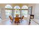 Sunlit breakfast nook features arched windows with views of the backyard and water at 10214 Arrowhead Dr, Punta Gorda, FL 33955