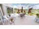 This covered lanai includes stylish seating, landscaping, and views of the lake and surrounding greenery at 10214 Arrowhead Dr, Punta Gorda, FL 33955