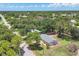 Aerial view showcases a charming home with lush greenery, neighborhood surroundings, and road access at 1053 Yarmouth St, Port Charlotte, FL 33952